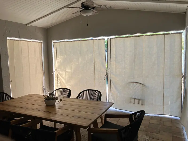 Cream Sunbrella privacy curtains for outdoor dining area in Kissimmee lanai