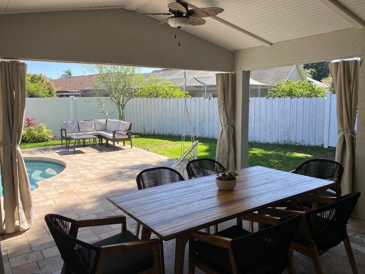 Cream curtains on covered patio with dining table