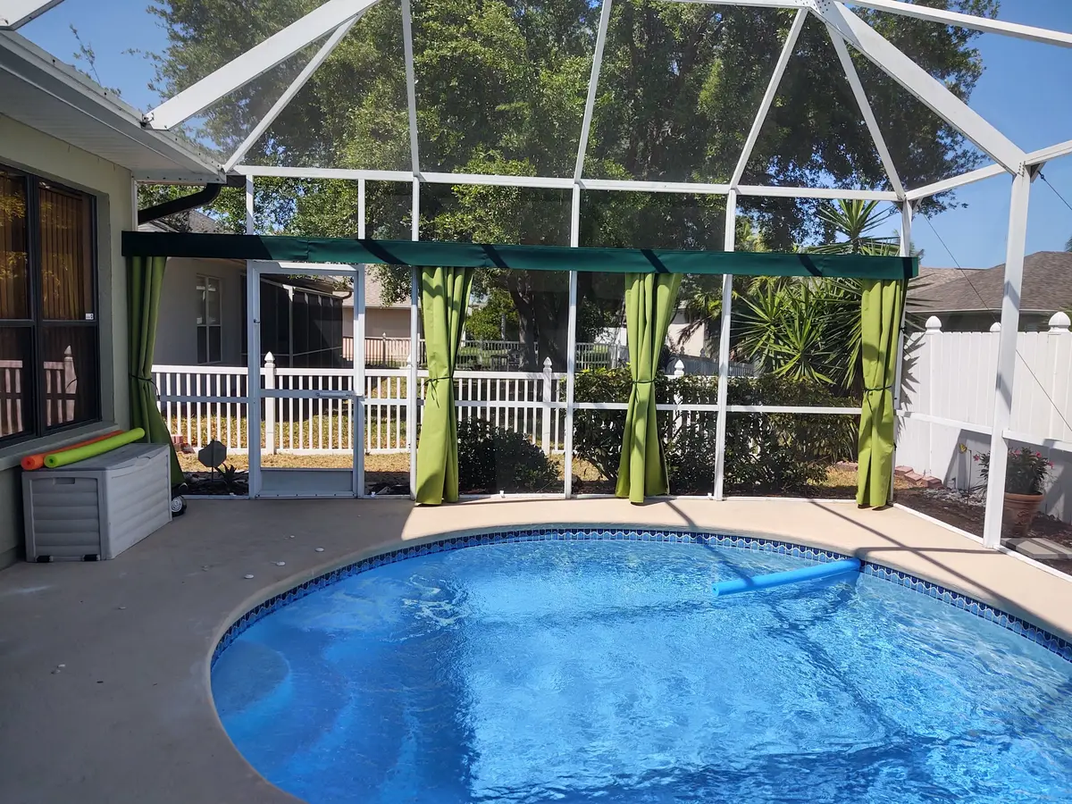 Green curtains with valance around pool