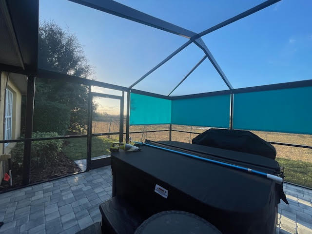 Teal roller shades on lanai with hot tub at sunset