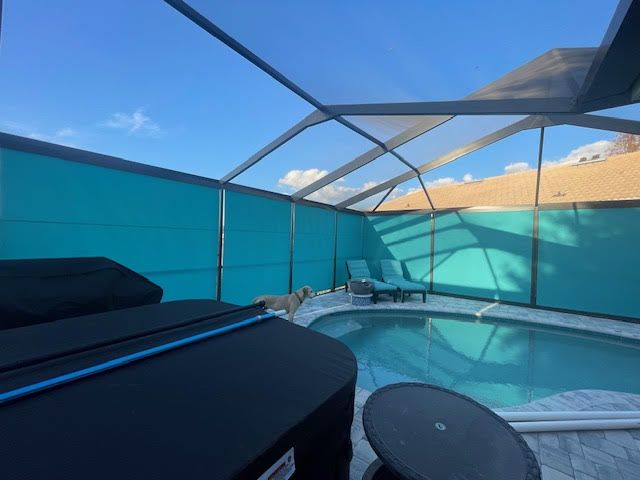 Wide view of teal roller shades in pool enclosure