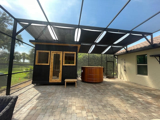 Black shade sails over patio with sauna and hot tub