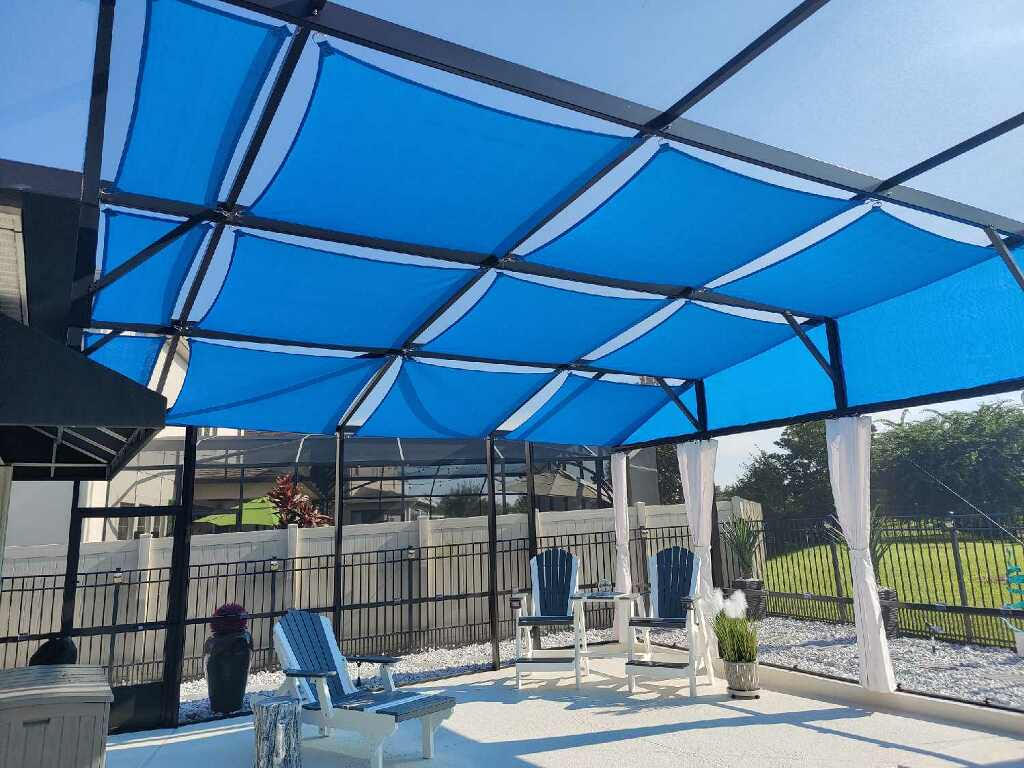 Bright blue shade sails over patio with Adirondack chairs